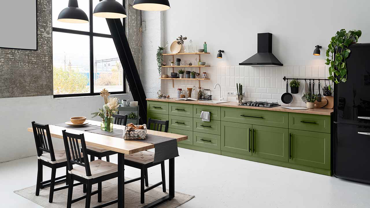 Wohnzimmer mit Küchenmöbeln, einem Esstisch und Stühlen. Die Küchenmöbel verfügen über Beschläge.